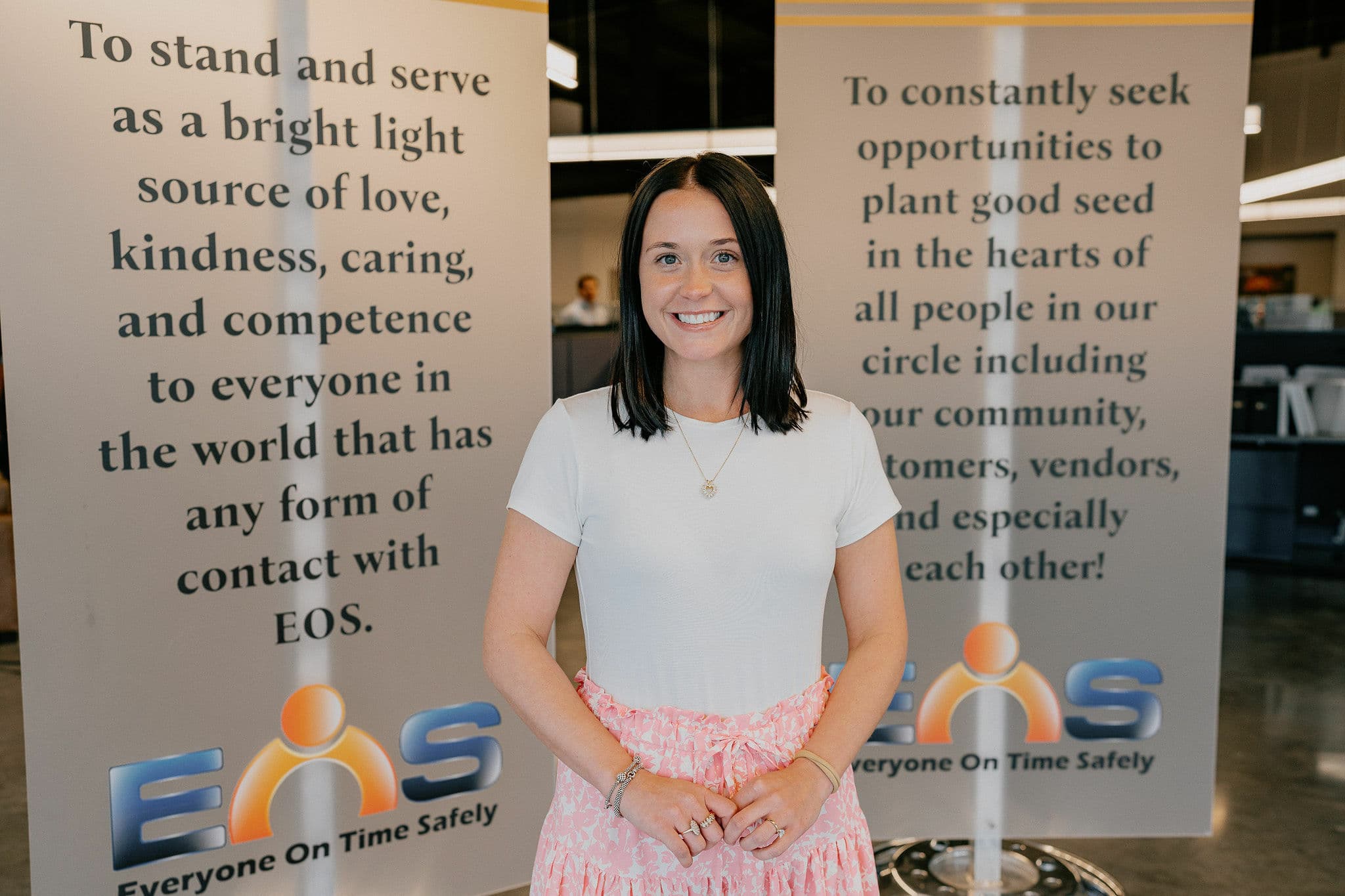 An EOS team member in the office between the company's mission banners